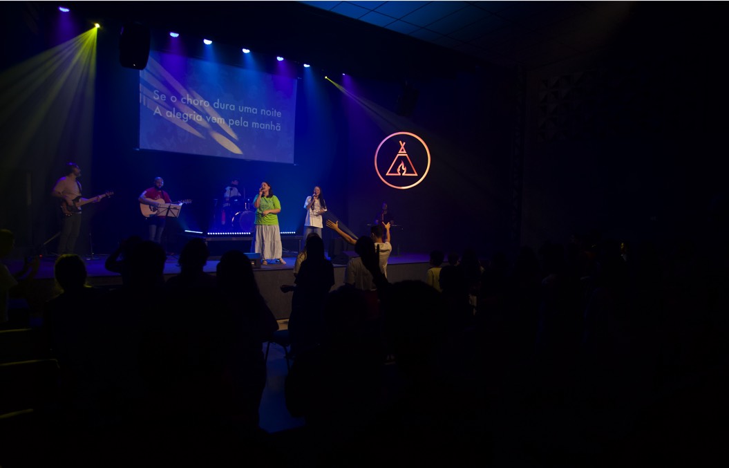 People at a concert facing the stage with various colours of paint powder in the air