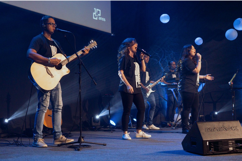 DJ facing a crowd at his deck. Photo with a purple hue